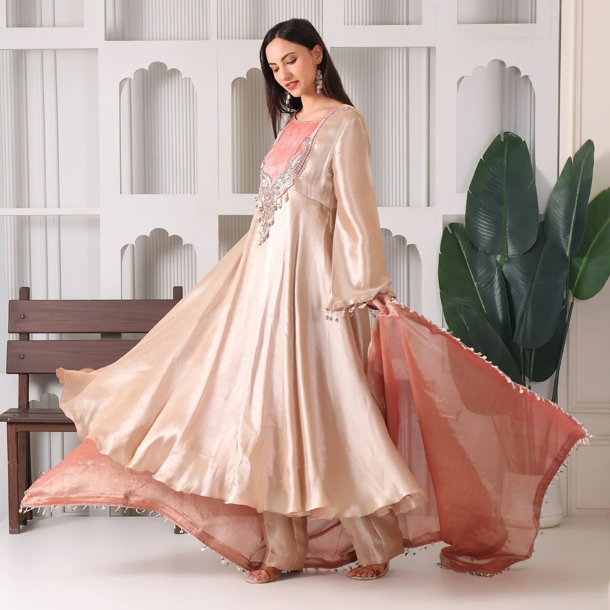 Woman in beige silk Anarkali suit with embroidery and pink dupatta, festive ethnic wear