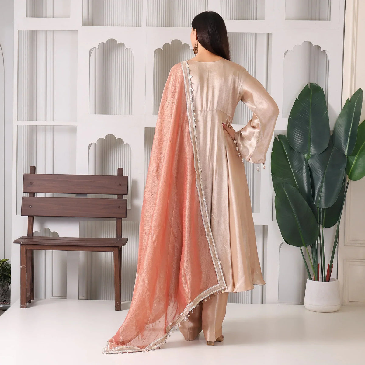 Woman in beige Anarkali suit with peach dupatta, ethnic wear, indoor setting