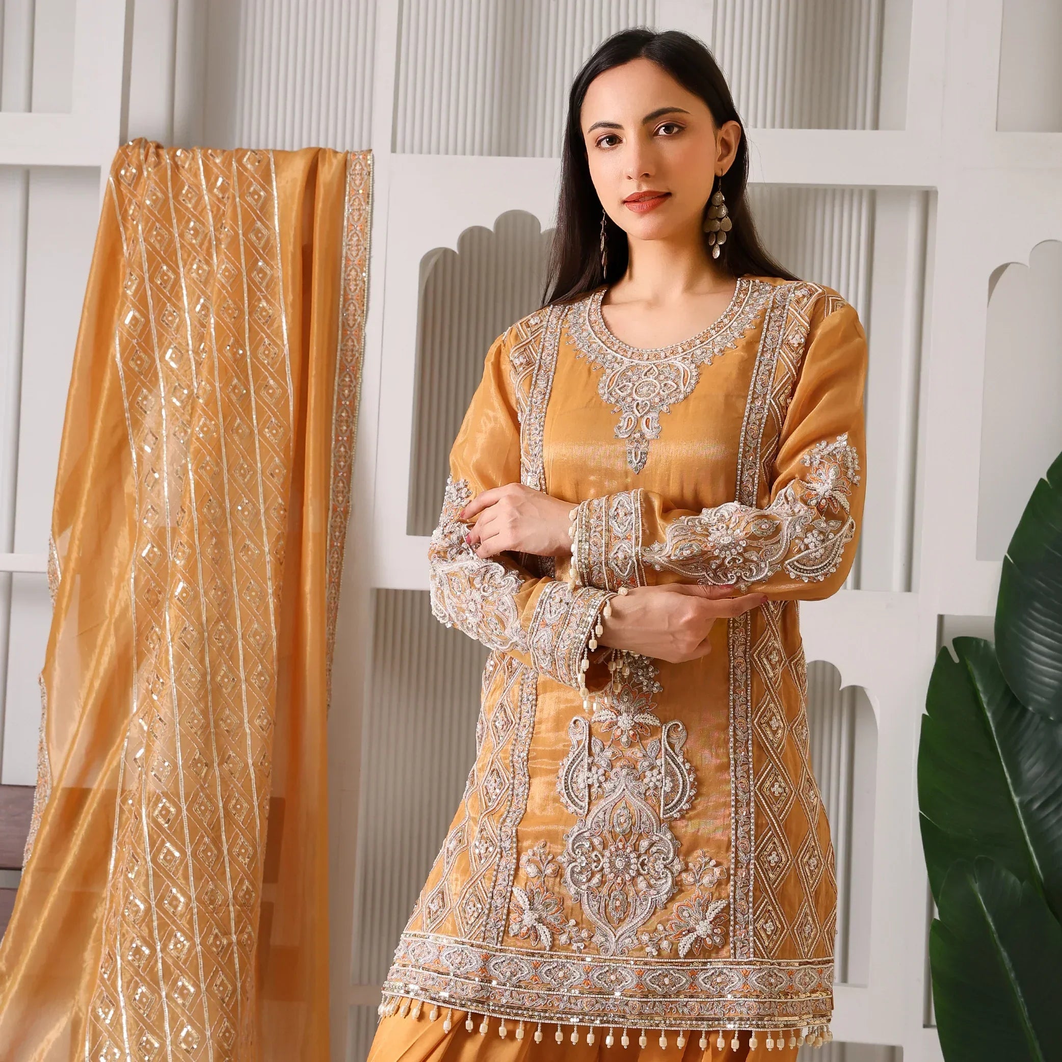 Woman in gold Banarasi Anarkali suit with intricate embroidery and matching dupatta