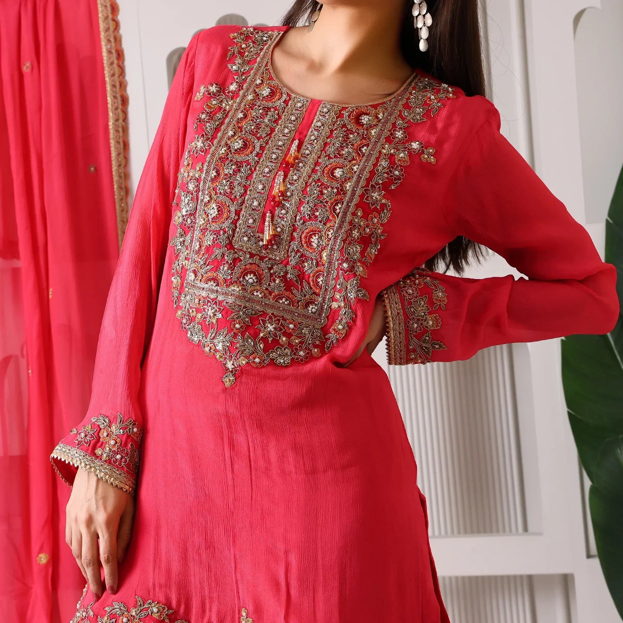 Woman wearing a hot pink Banarasi Anarkali suit with intricate gold embroidery