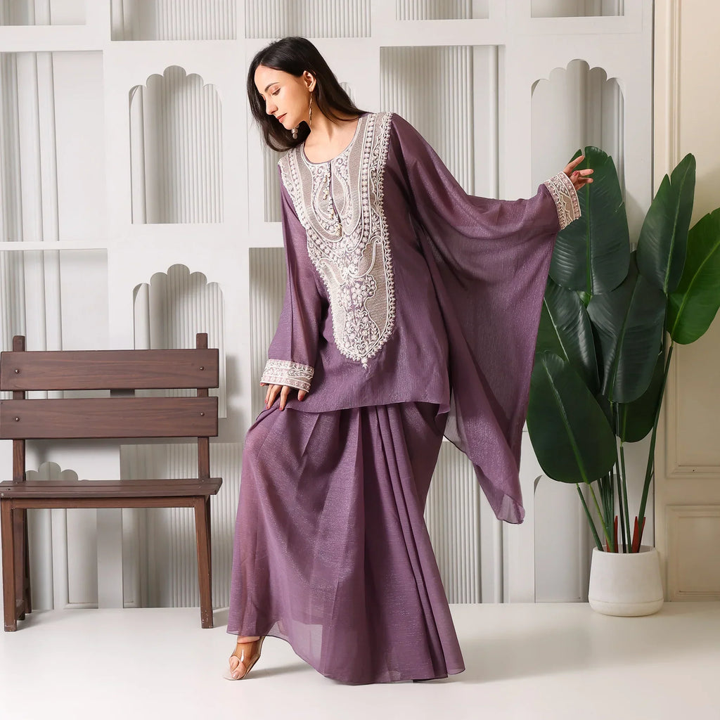 Woman in mauve embroidered ethnic suit with flared sleeves, festive Indian outfit