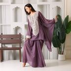 Woman in mauve embroidered ethnic suit with flared sleeves, festive Indian outfit