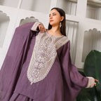 Woman wearing mauve ethnic suit with intricate white embroidery, festive outfit fashion