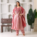 Woman wearing pink Banarasi Anarkali suit set with dupatta, festive ethnic outfit indoors