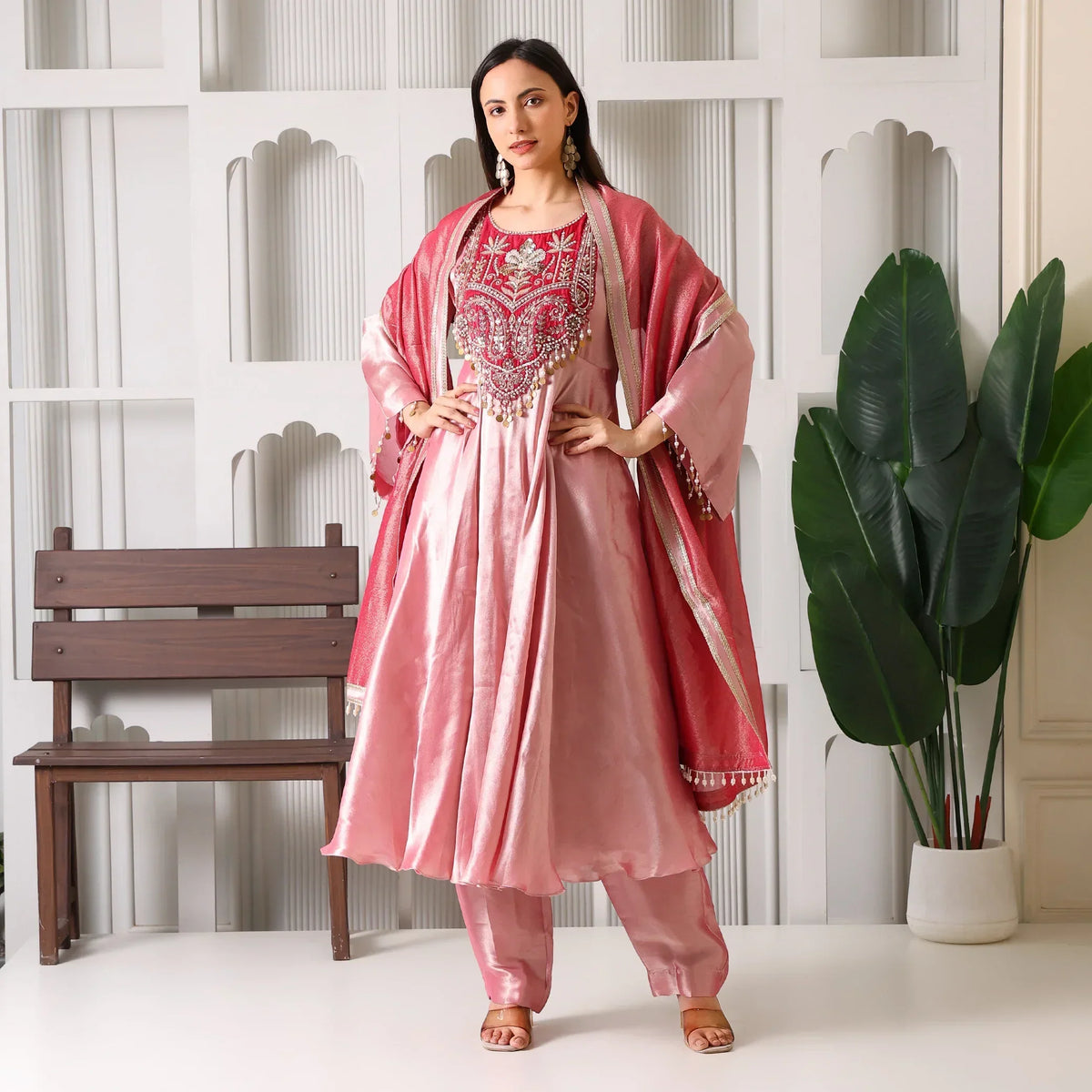 Woman wearing pink Banarasi Anarkali suit set with dupatta, festive ethnic outfit indoors