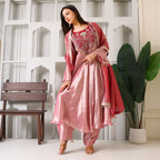 Woman wearing pink Banarasi Anarkali suit set with dupatta, posing indoors
