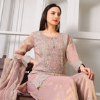 Woman wearing mauve embroidered ethnic suit with dupatta, sitting on bench indoors