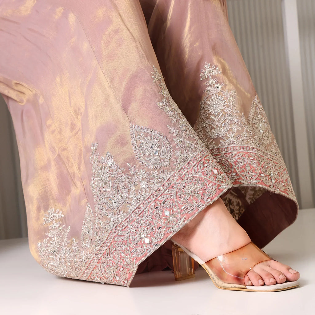 Close-up of pastel Banarasi suit pants with intricate silver embroidery and transparent heels