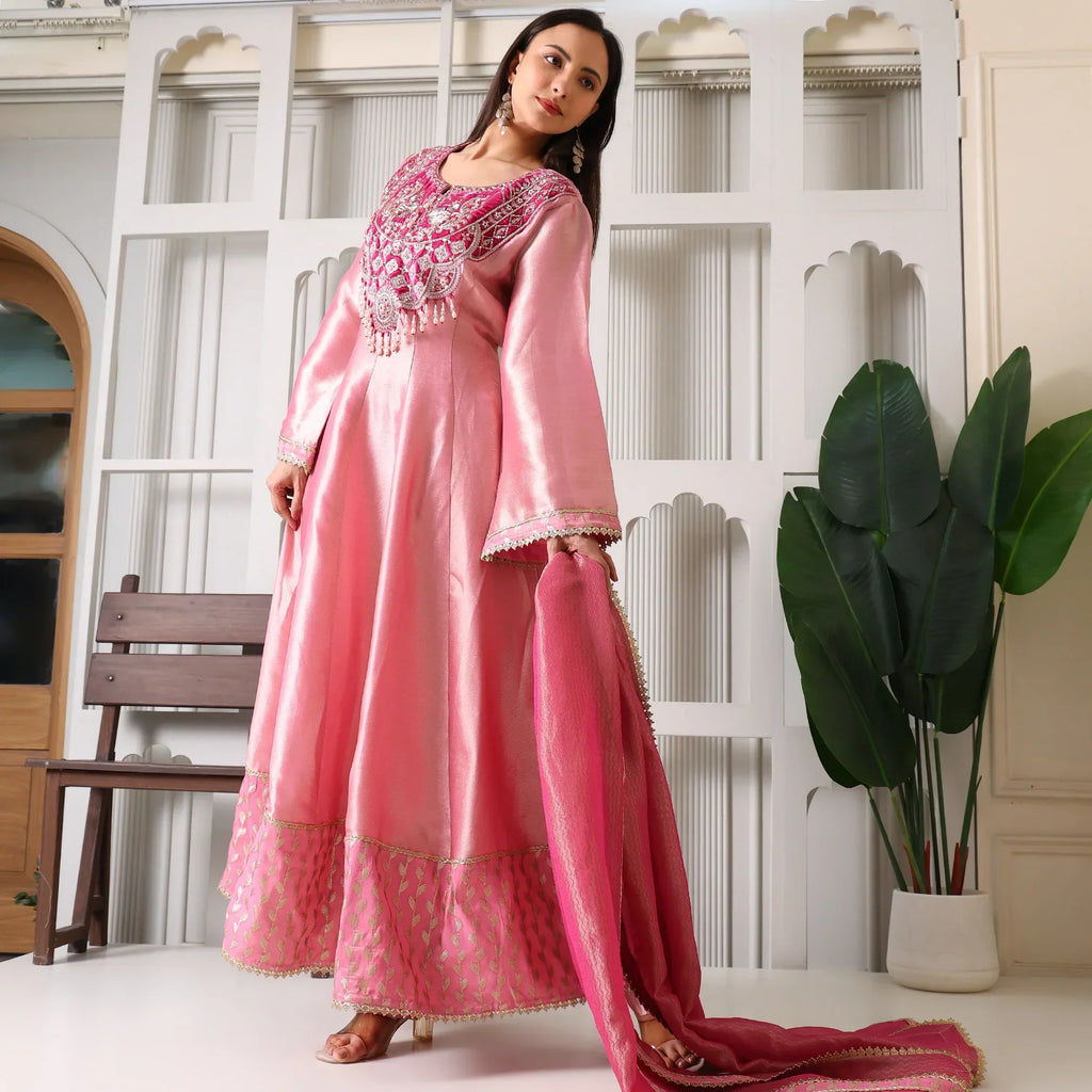 Woman wearing pink Banarasi Anarkali suit with embroidered yoke, holding matching dupatta