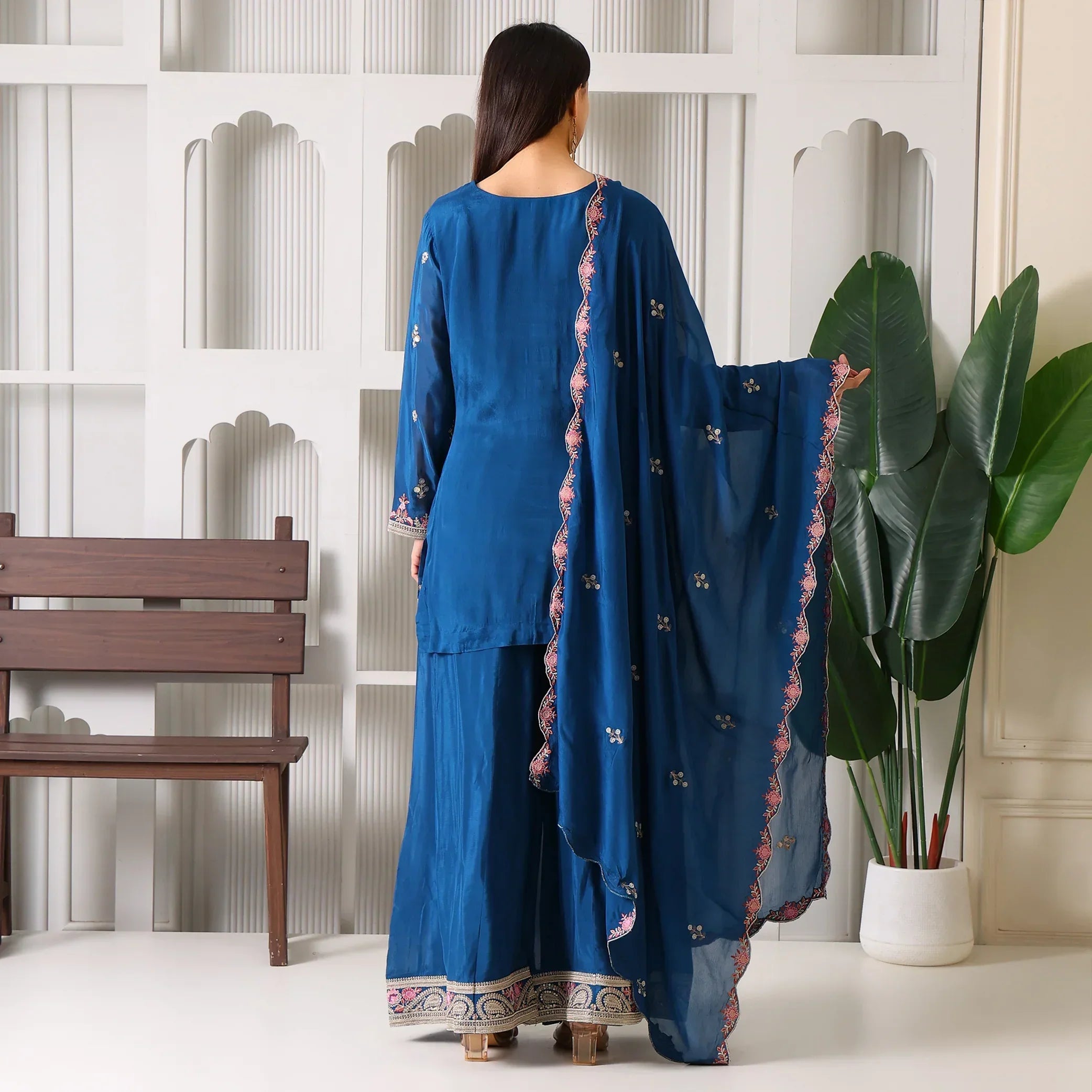 Woman in blue embroidered ethnic suit with dupatta, palazzo pants, and floral border