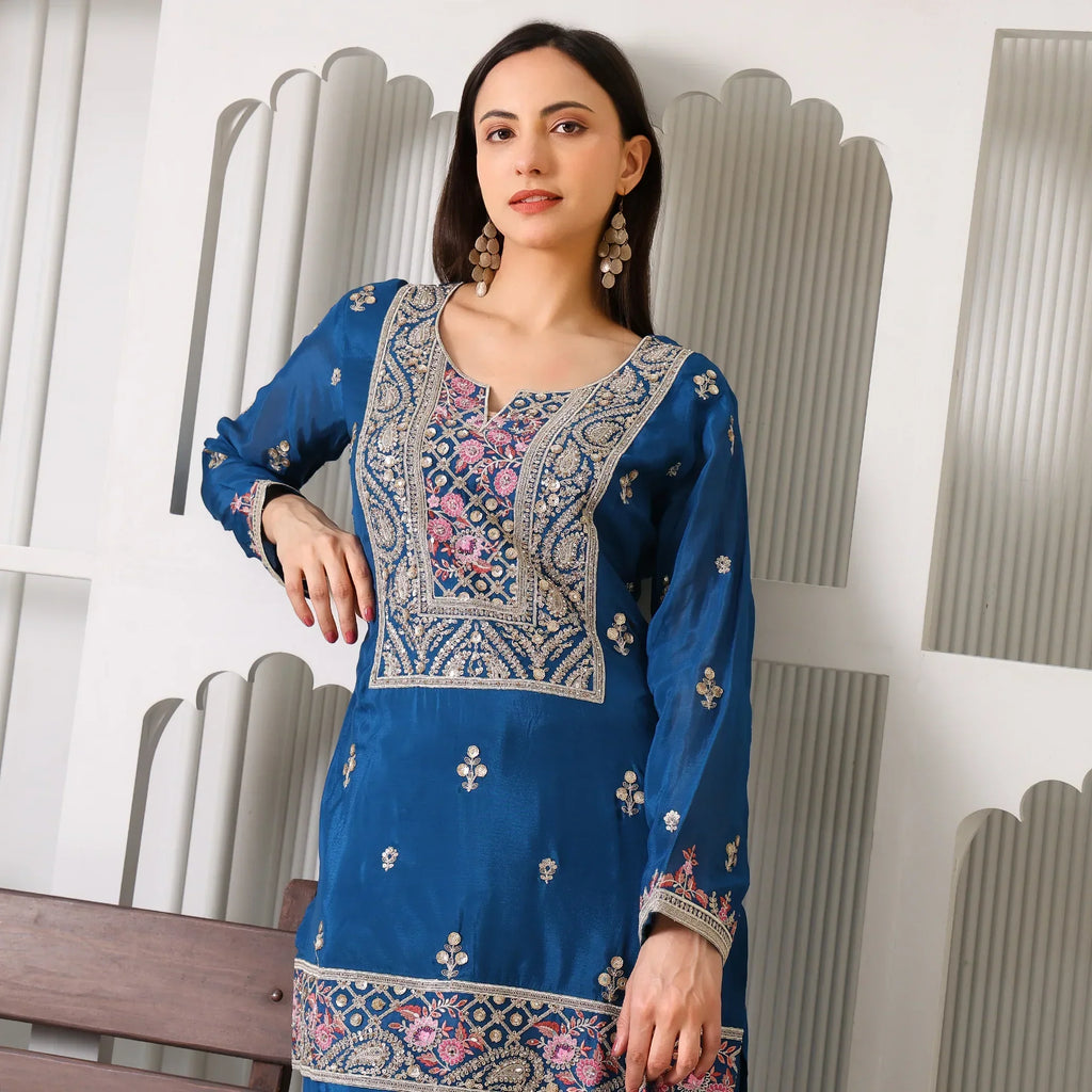 Woman in blue Banarasi Anarkali suit with intricate gold and pink embroidery, festive wear
