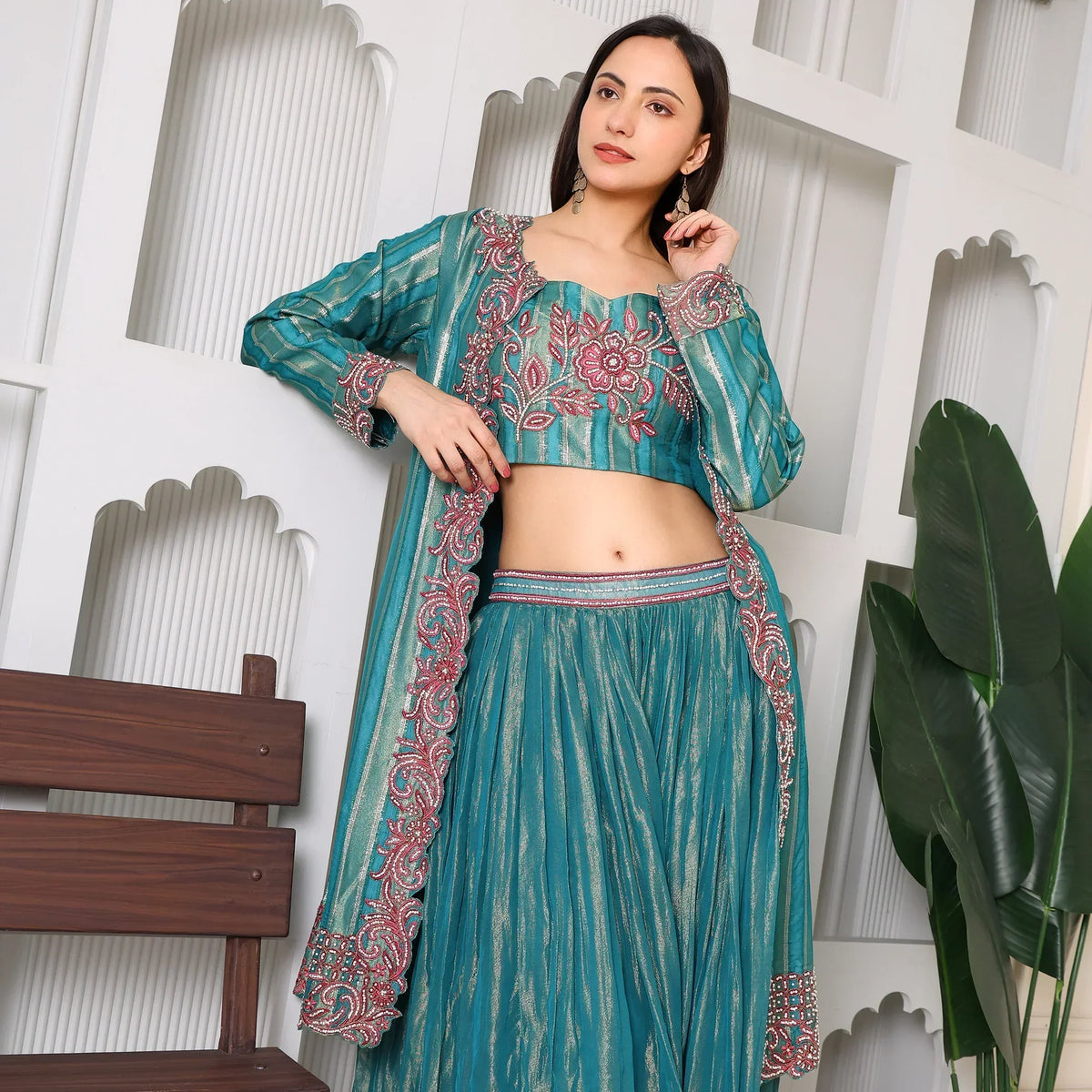 Woman wearing teal embroidered ethnic three-piece suit with floral designs, festive wear