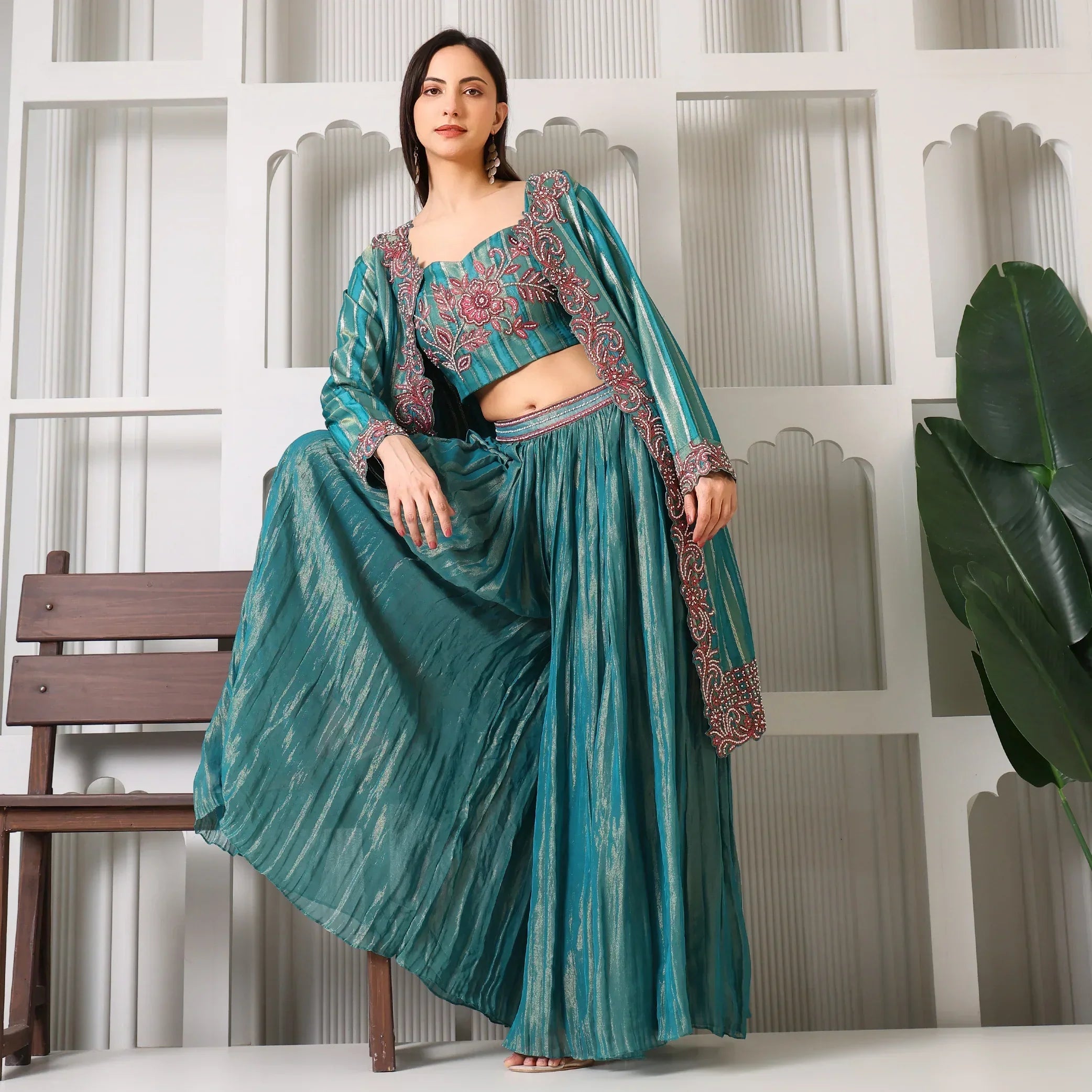Woman in teal Banarasi embroidered ethnic three-piece set with dupatta, posing indoors