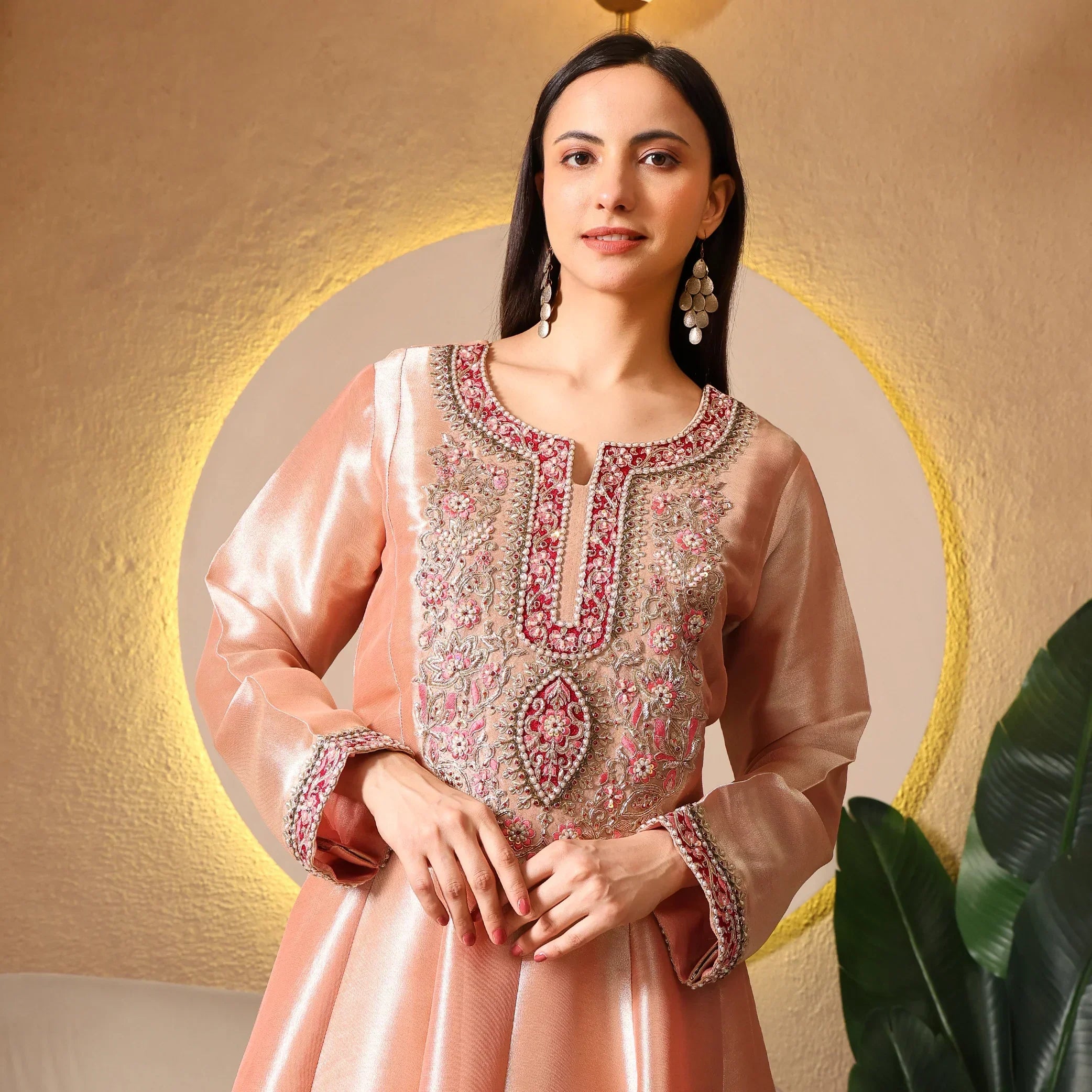 Woman wearing peach Banarasi Anarkali suit with intricate floral embroidery, festive wear