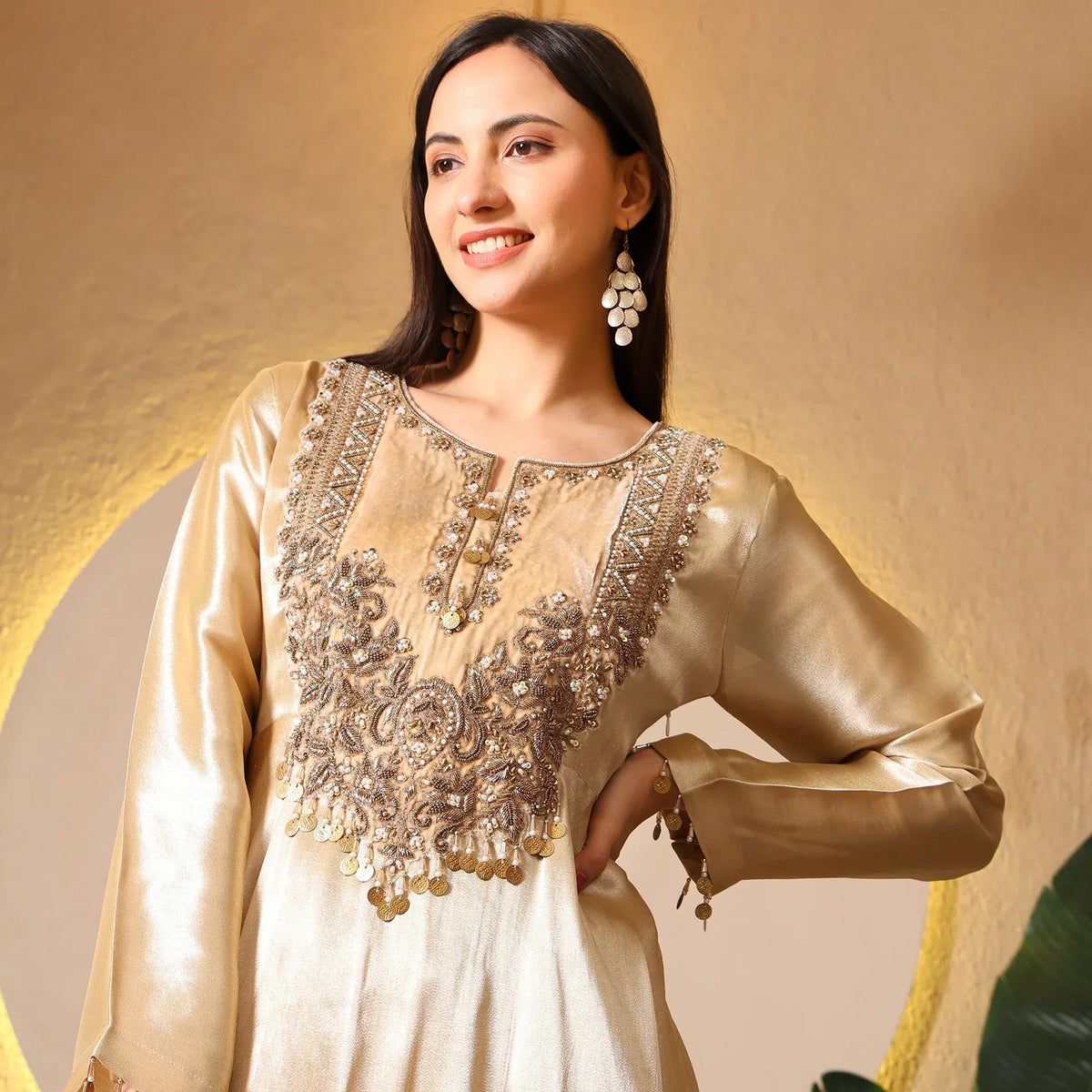 Woman wearing gold embroidered Anarkali suit with statement earrings, festive ethnic wear