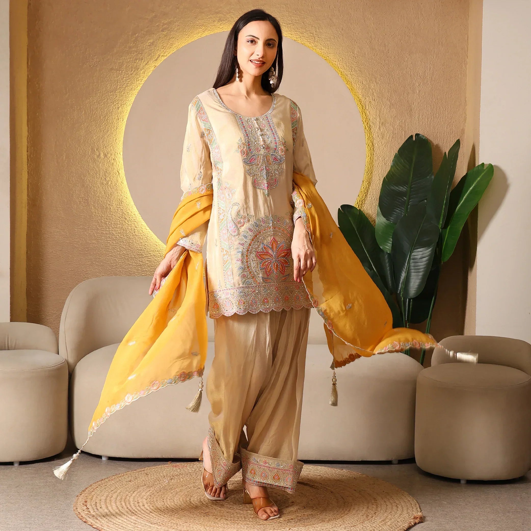 Woman in beige embroidered ethnic suit with yellow dupatta, designer festive outfit