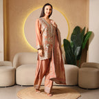 Woman wearing an embroidered ethnic suit with dupatta in a modern living room setting