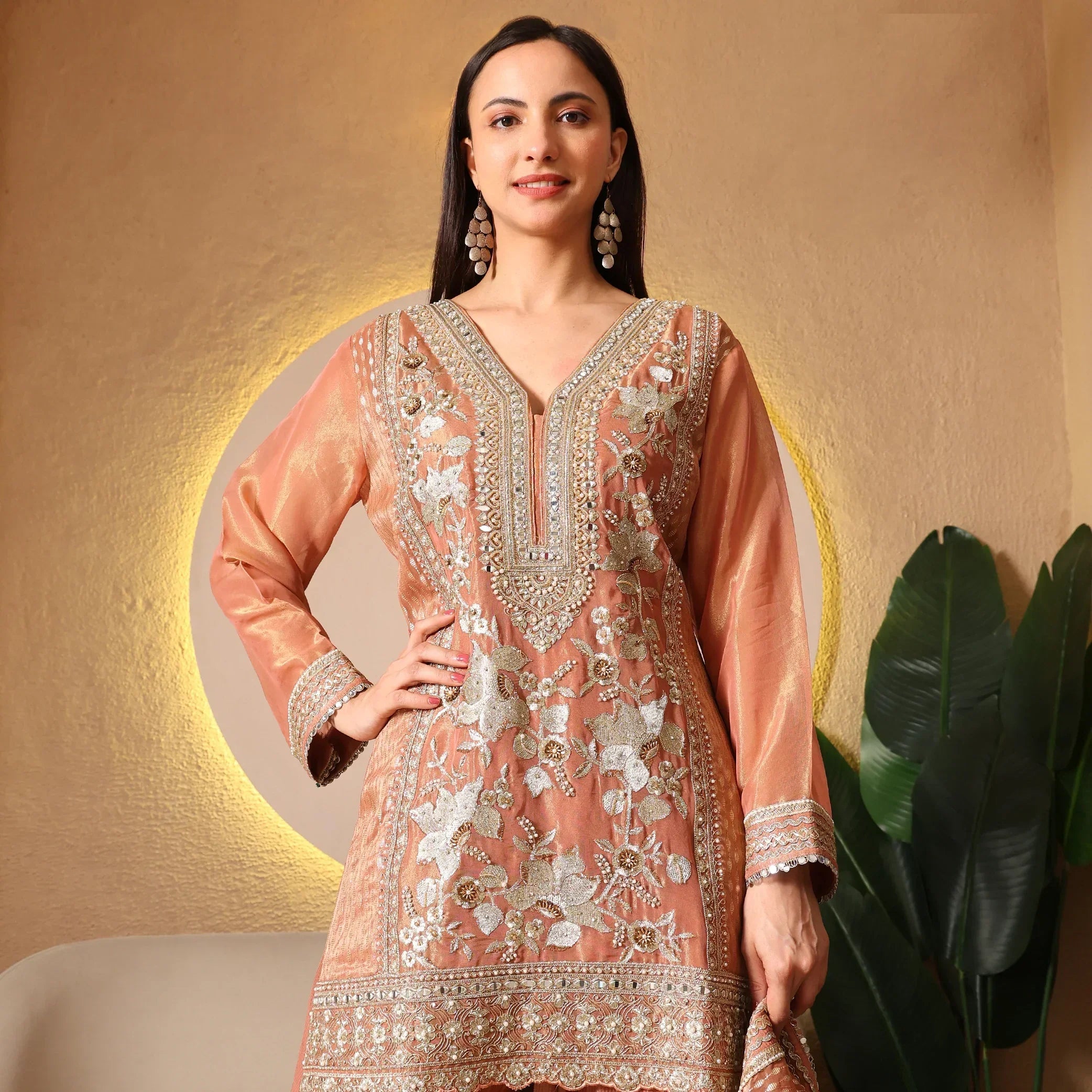Woman wearing peach embroidered Anarkali suit with floral design, festive ethnic wear