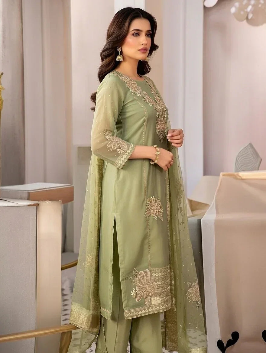 Woman wearing sage green embroidered Anarkali suit with sheer dupatta in elegant indoor setting