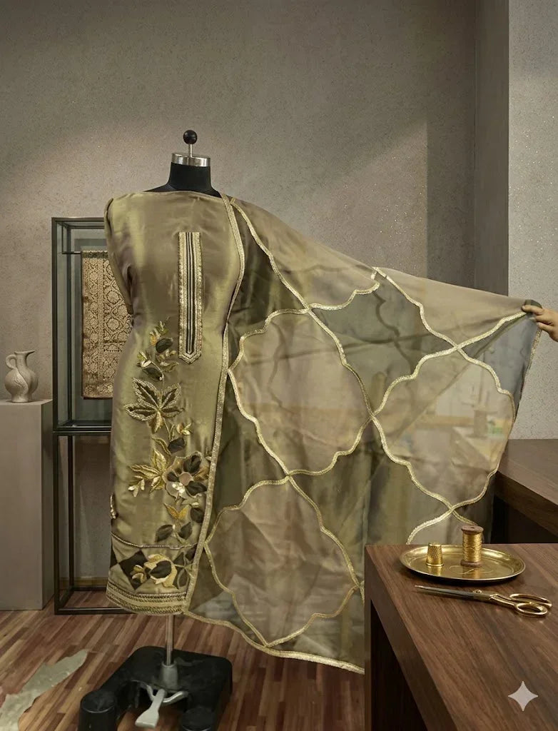 Designer olive green Anarkali suit with floral embroidery and sheer dupatta displayed on mannequin