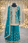 Teal ethnic Anarkali suit with floral embroidery, dupatta, and pleated skirt, perfect for weddings