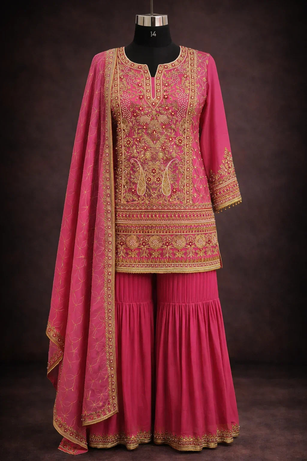 Pink designer ethnic sharara suit with gold embroidery and dupatta, displayed on mannequin
