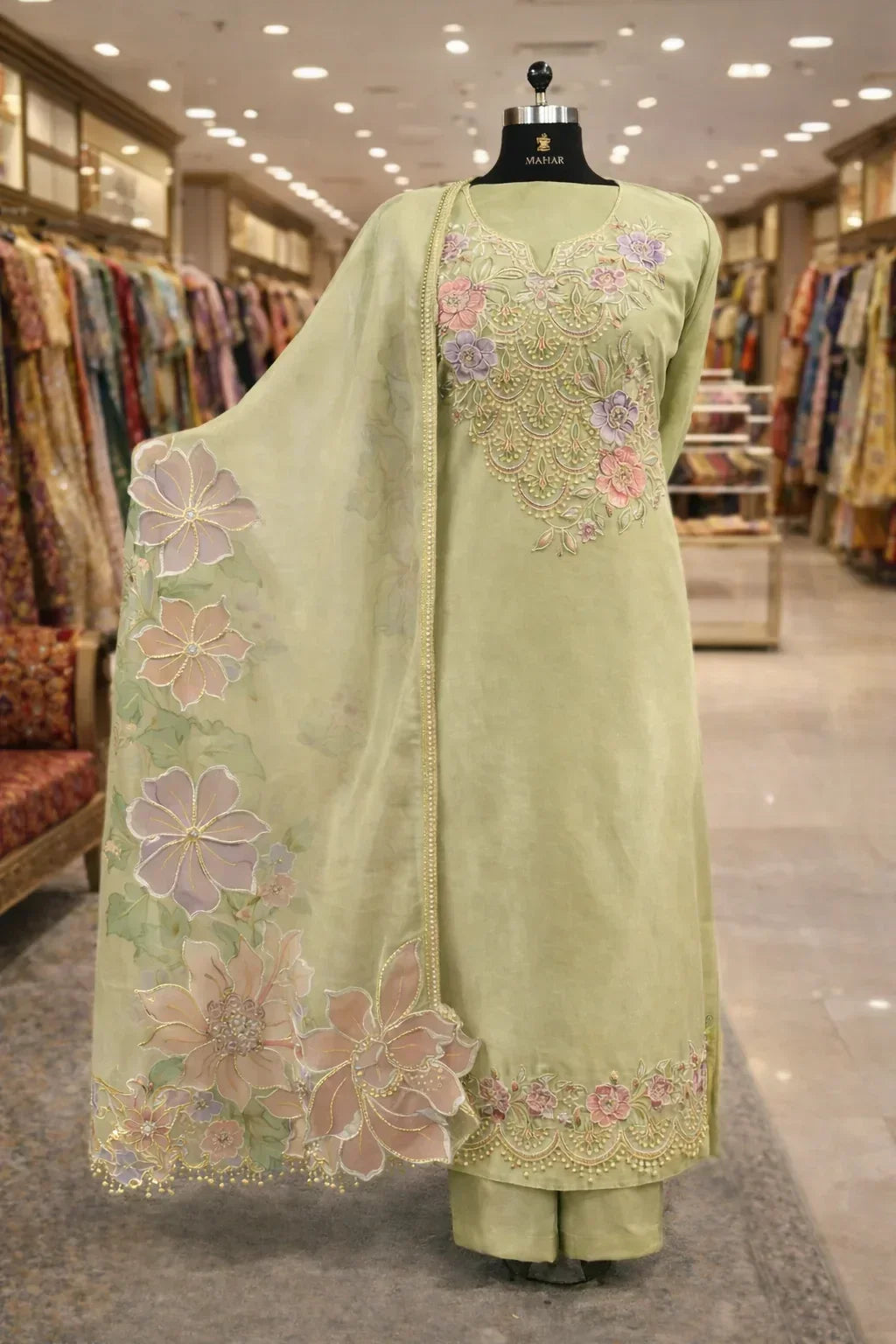 Pastel green embroidered Anarkali suit with floral motifs and matching dupatta on mannequin