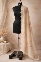 Beige ethnic dupatta with pastel circular embroidery and scalloped lace border on mannequin