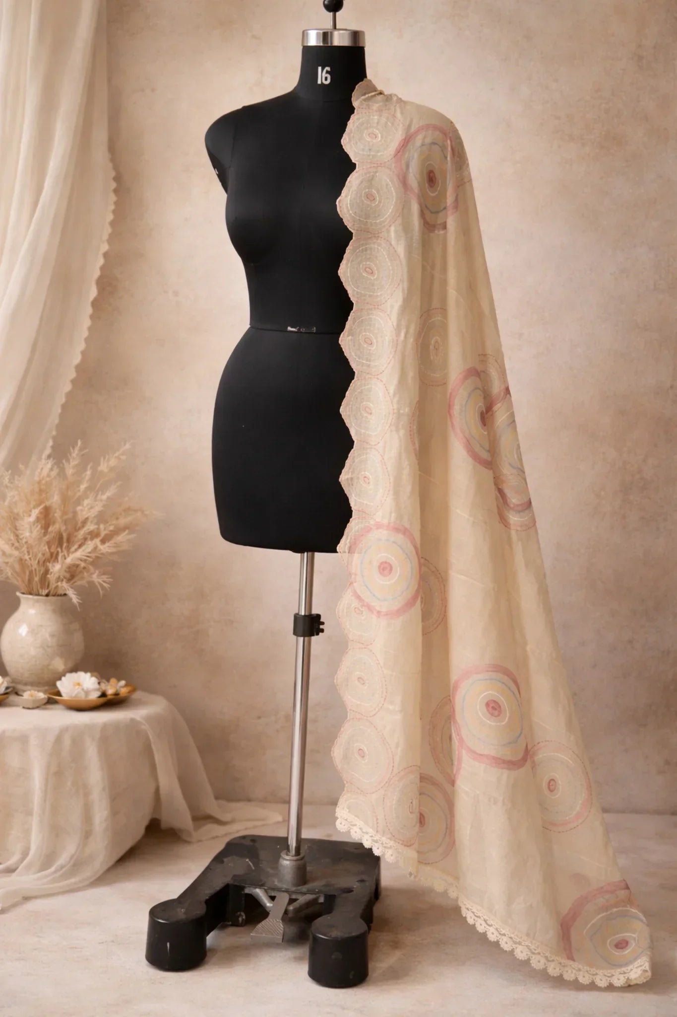 Beige ethnic dupatta with pastel circular embroidery and scalloped lace border on mannequin