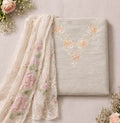 Light grey ethnic suit set with floral embroidery and sheer dupatta, surrounded by roses