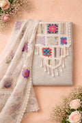 Embroidered ethnic suit fabric with colorful floral motifs and tassels, flatlay with roses