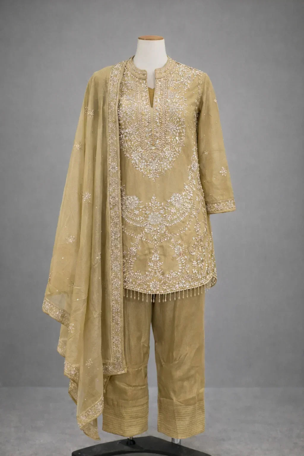 Gold embroidered ethnic three-piece suit with long kurta, straight pants, and matching dupatta