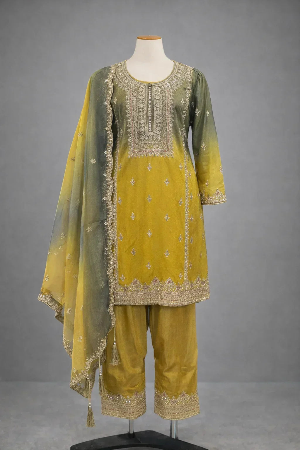 Yellow and green embroidered ethnic suit with matching dupatta and pants on mannequin
