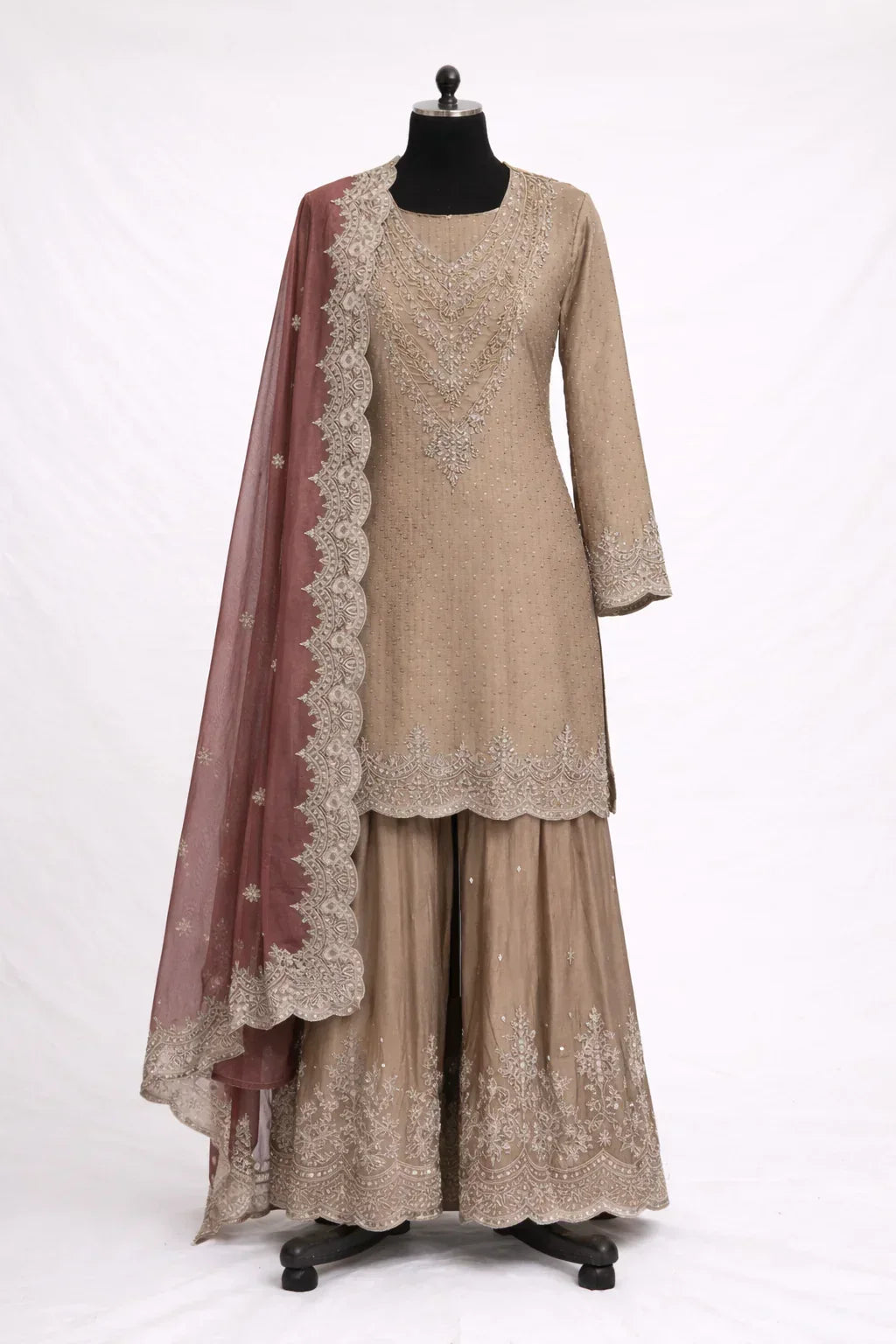 Designer beige ethnic suit with intricate embroidery and maroon dupatta on mannequin