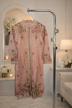 Pink velvet ethnic long jacket with floral embroidery and gold trim, displayed indoors