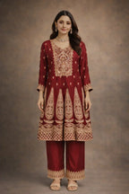 Woman wearing maroon Banarasi Anarkali suit with gold embroidery for festive occasions