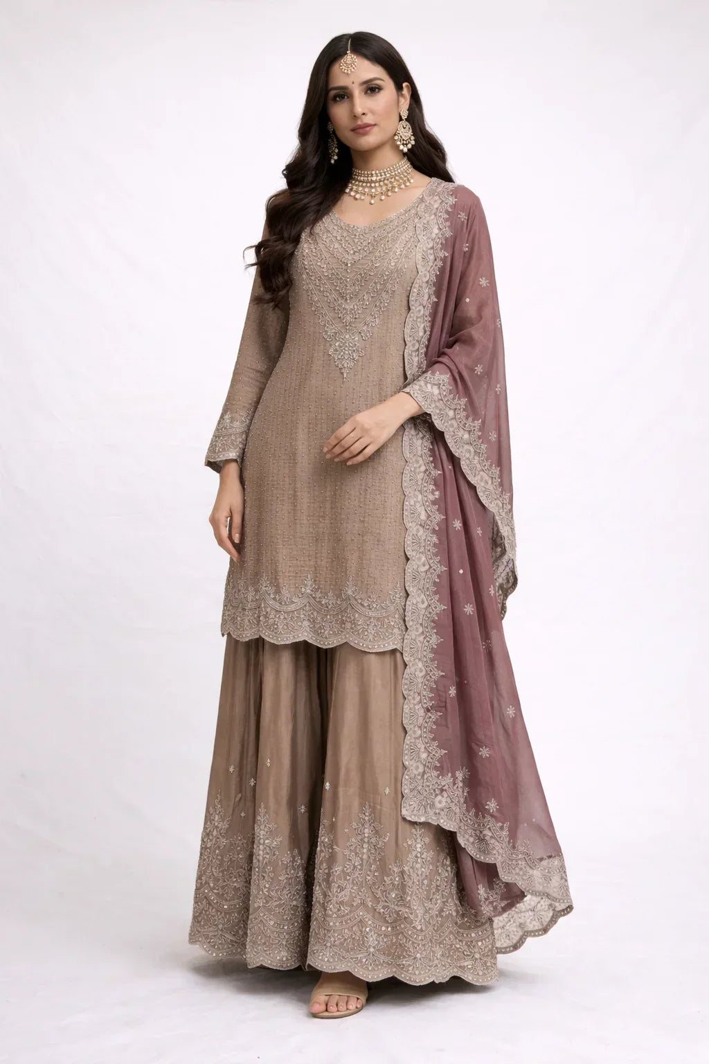 Woman wearing a beige embroidered Anarkali suit with dupatta, ideal for weddings or festive occasions