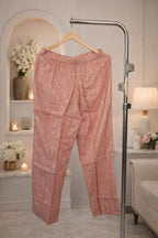 Dusty pink ethnic pants with gold detailing, displayed on hanger in elegant room setting
