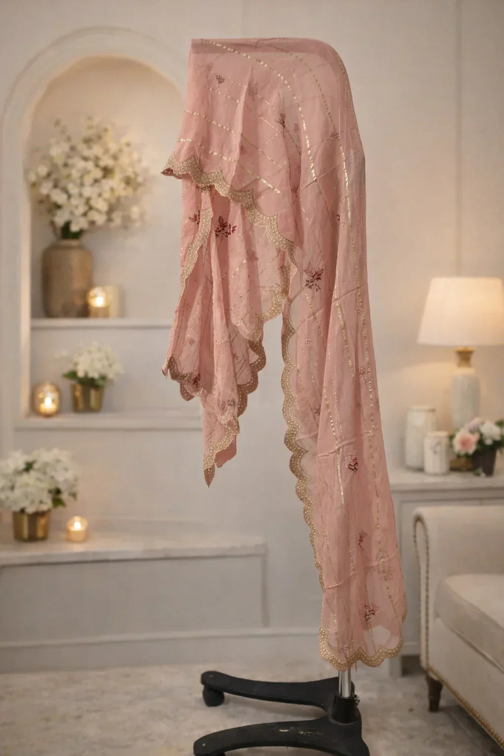 Pastel pink embroidered dupatta with gold sequin accents displayed in an elegant room