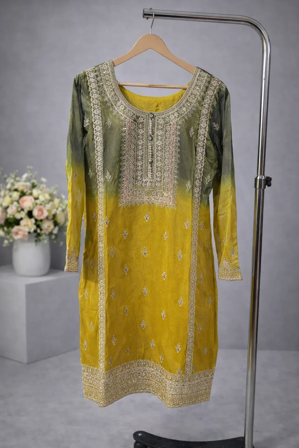 Yellow and green embroidered ethnic kurta with intricate detailing, displayed on hanger