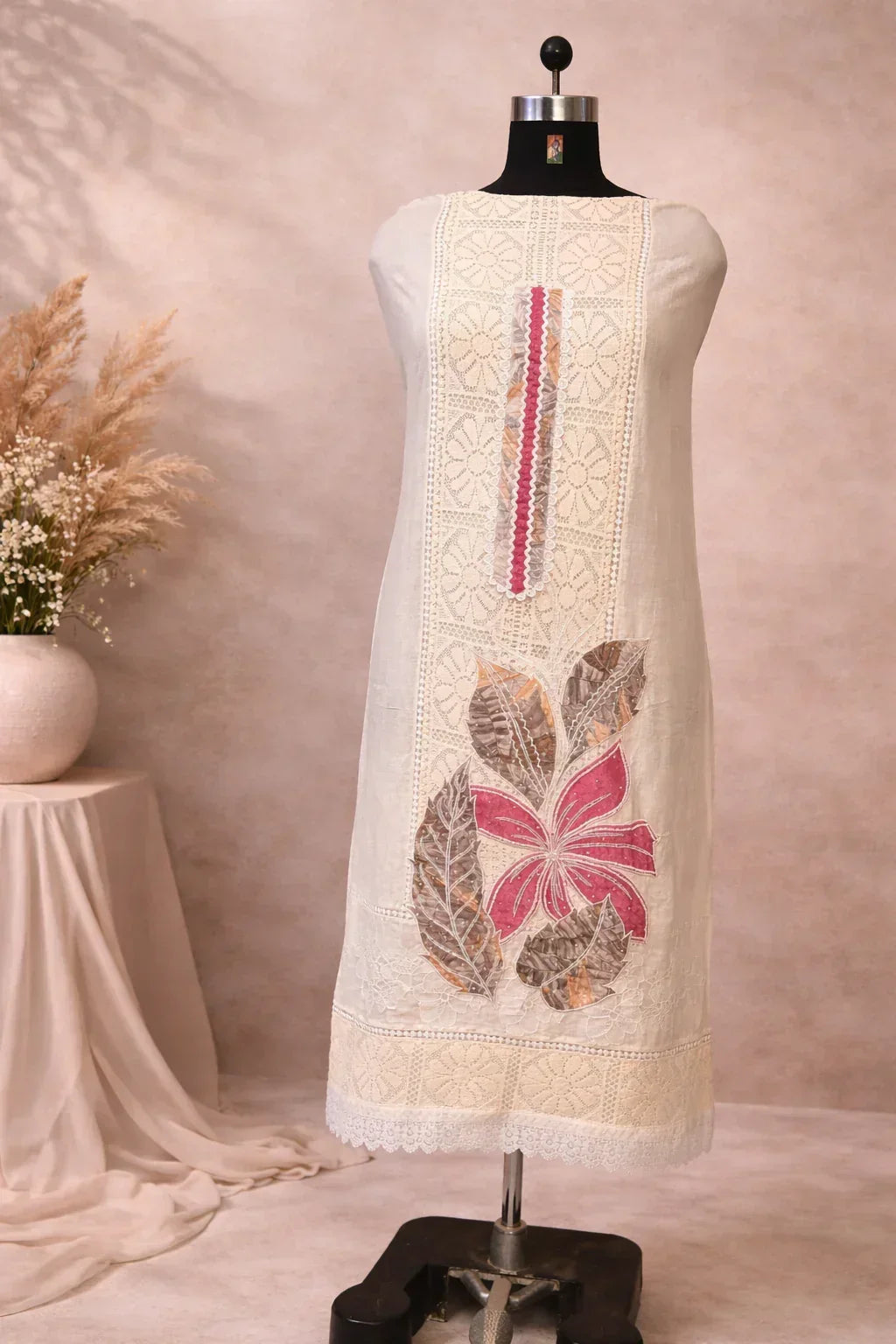 Beige embroidered kurta with pink floral design and lace detailing on a mannequin