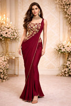 Woman in maroon embroidered designer saree with gold floral details, festive ethnic wear