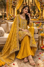 Woman in yellow embroidered Anarkali suit with dupatta, dressed for festive or wedding occasion, seated on a sofa in a floral decorated setting