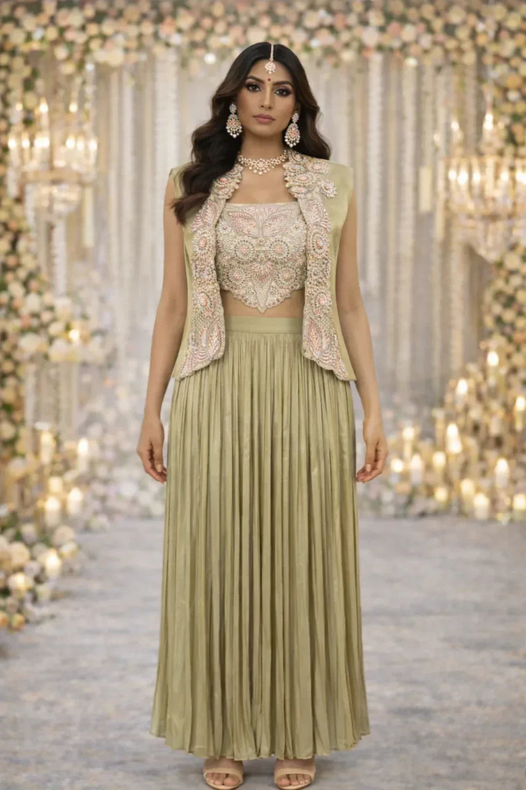 Woman in pastel green embroidered crop top, vest, and long pleated skirt, styled for wedding or festive occasions