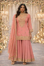 Woman in peach embroidered Anarkali suit with palazzo pants and dupatta, festive setting