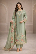 Woman wearing sage green embroidered Anarkali suit with floral dupatta, festive ethnic wear