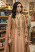 Woman in peach Banarasi Anarkali suit with gold embroidery, standing in ethnic wear boutique
