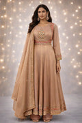 Woman wearing a beige Banarasi Anarkali suit with intricate embroidery, festive ethnic attire