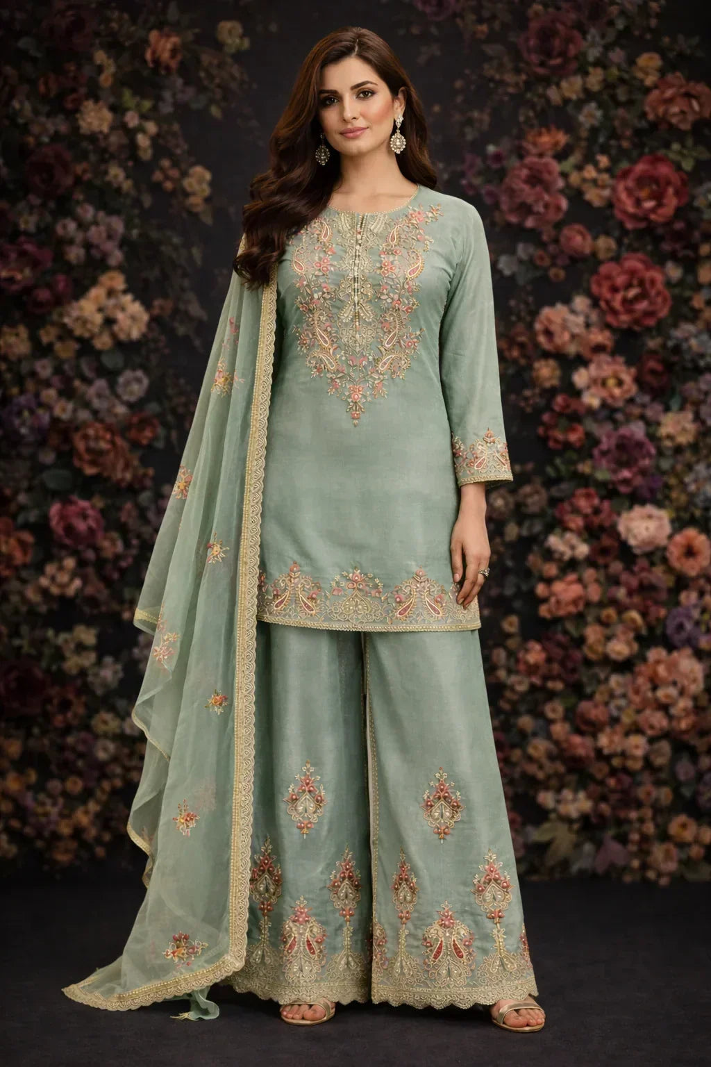 Woman wearing a pastel green ethnic palazzo suit with floral embroidery and matching dupatta