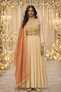 Woman in cream Banarasi Anarkali suit with gold embroidery and peach dupatta, festive setting